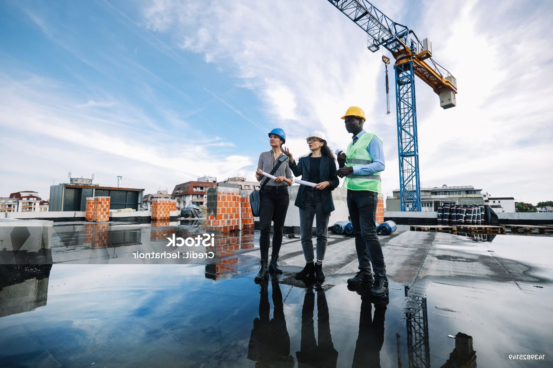 Engineers reviewing plans on a rooftop construction site